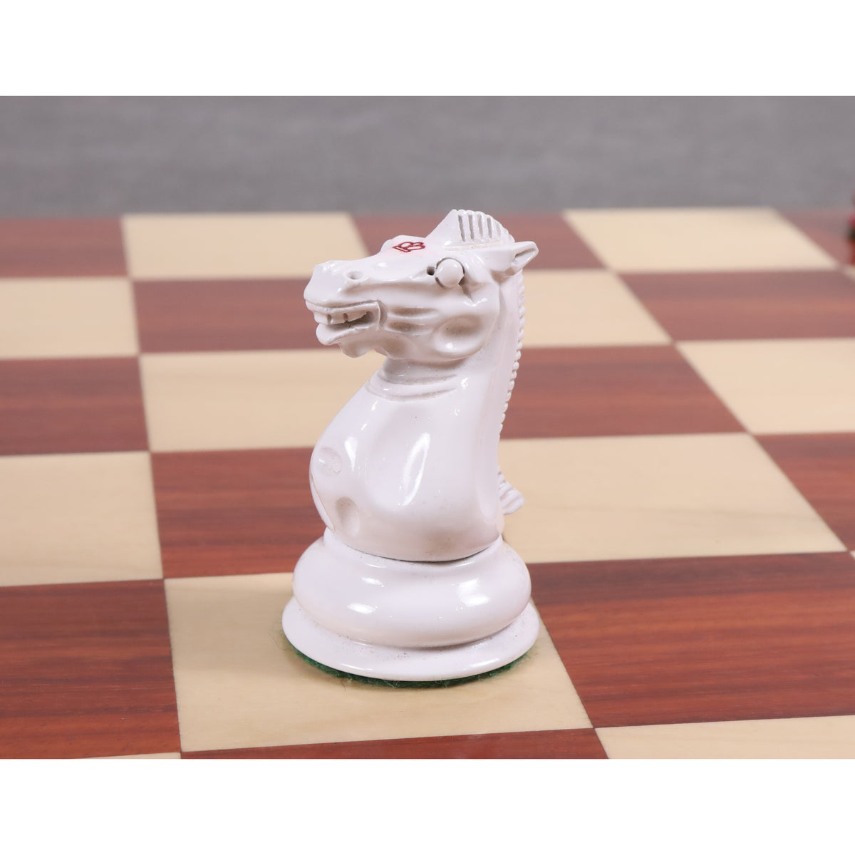 White bone-style knight from the 1849 Jacques Cook Staunton collectors set on a wooden board.