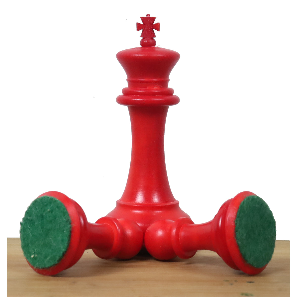 Crimson camel bone king piece from the 1849 Jacques Cook set showing green billiard cloth felt base.