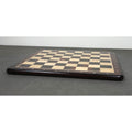 Perspective view of a 19 inch flat rosewood and maple wood chessboard on a grey surface.