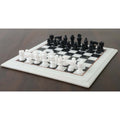 Handcarved 12-inch marble chess set arranged on a dark wooden surface.
