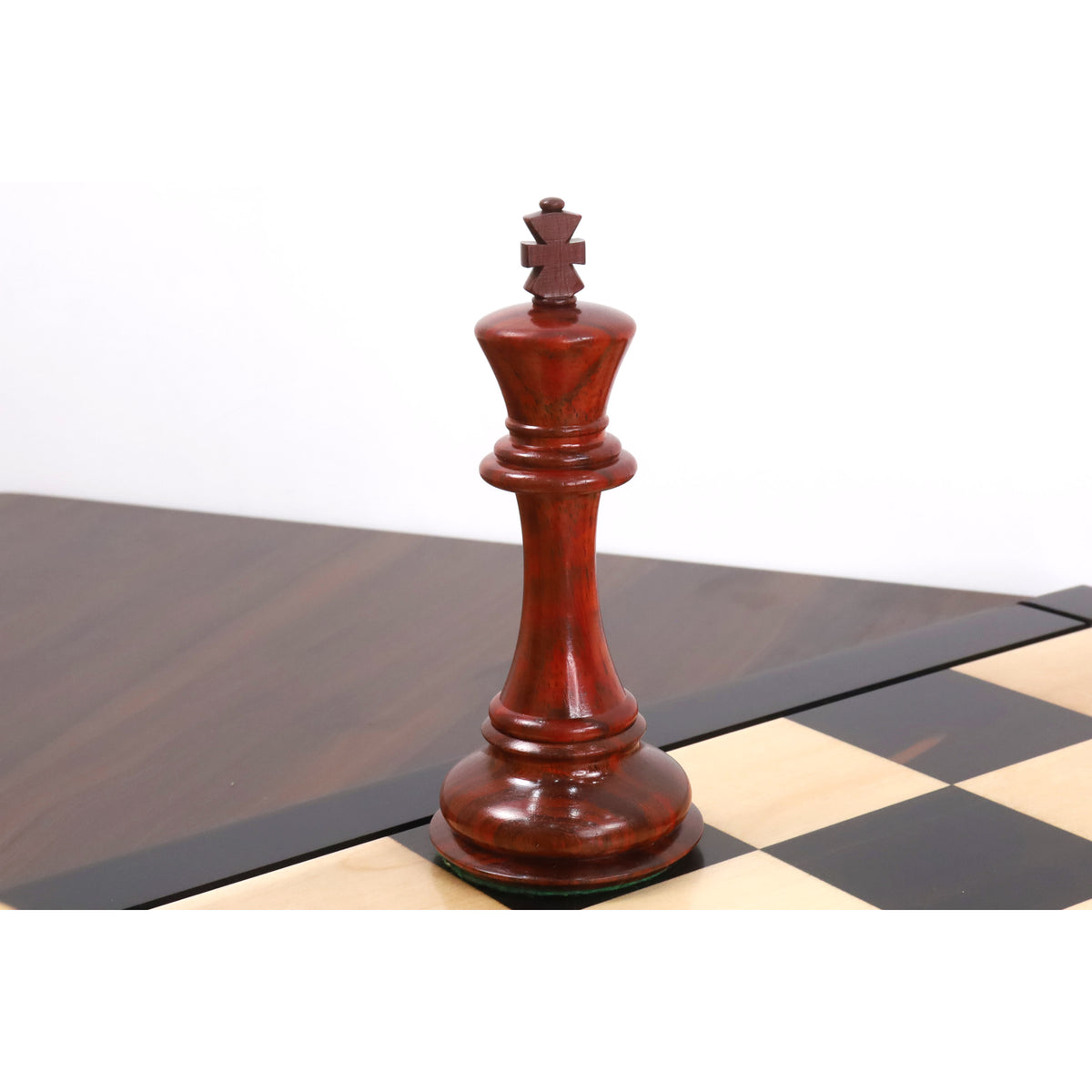 Triple weighted bud rosewood king piece from the luxury Staunton chess collection standing on a board.