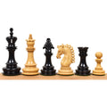 Six luxury Carvers Art chess pieces in ebony wood and boxwood lined up on a wooden rail.