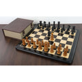 Complete Calvert Pre-Staunton chess set on a glossy black and maple wooden board accompanied by a brown storage box.