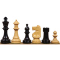Alternating black and white W.T. Pinney Staunton chess pieces arranged in a row from King to Pawn on a wooden surface.