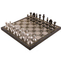 A complete 12" luxury brass chess set featuring polished silver and black pieces arranged on its intricately engraved metallic board.