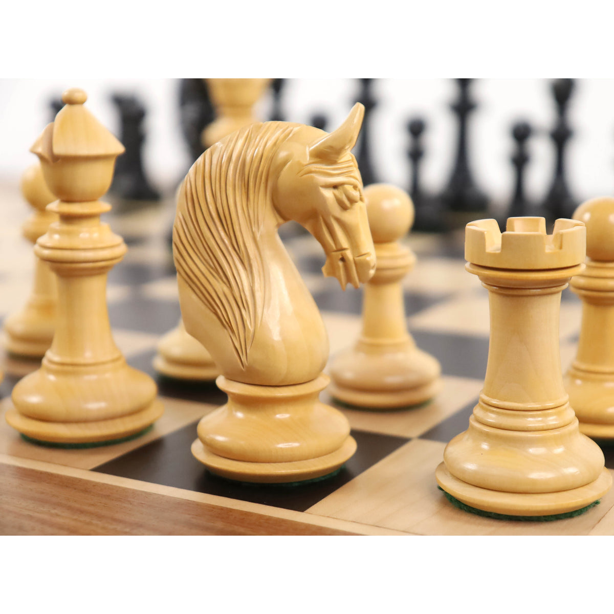 Hand-carved 4.6-inch boxwood knight chess piece on a luxury wooden board.
