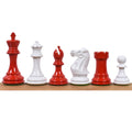 A line-up of red and white weighted Staunton chess pieces on a wooden surface.