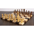 A set of Minimalist Tower Series chess pieces on a wooden board, featuring a natural boxwood king placed in the center.