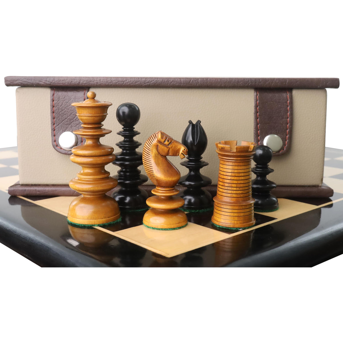 Grouping of antique and ebony Calvert chess pieces including a knight, rook, and queen in front of a box.