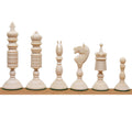 Set of white antique pre-Staunton chess pieces arranged on a wooden board.