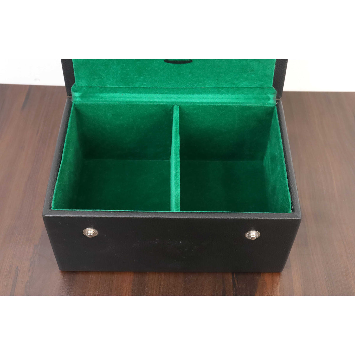 Open black storage box with two internal compartments lined in green felt for chess pieces.
