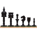 Black dyed camel bone English pre-Staunton chess pieces lined up in a row.