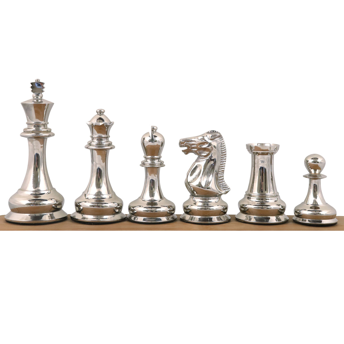 Polished silver brass luxury chess pieces aligned on a wooden surface against a white backdrop.