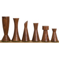 Golden rosewood dark pieces of the Minimalist Tower Series chess set arranged in a descending line from king to pawn.