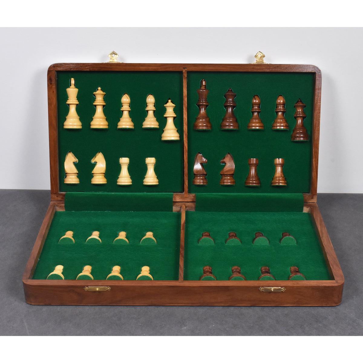 Green felt-lined interior of a travel chess set case with secure individual slots for wooden chess pieces.