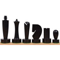 Modern minimalist ebonised boxwood chess pieces from the Berliner series lined up on a wooden base.