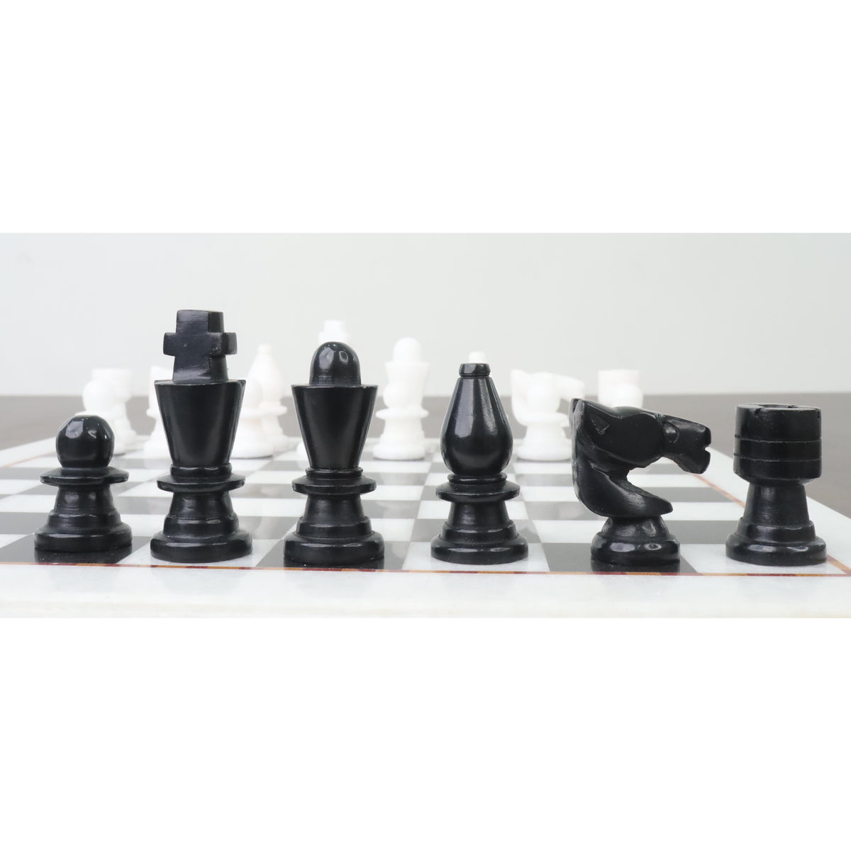 Close-up of handcarved black marble chess pieces on a 12-inch board.