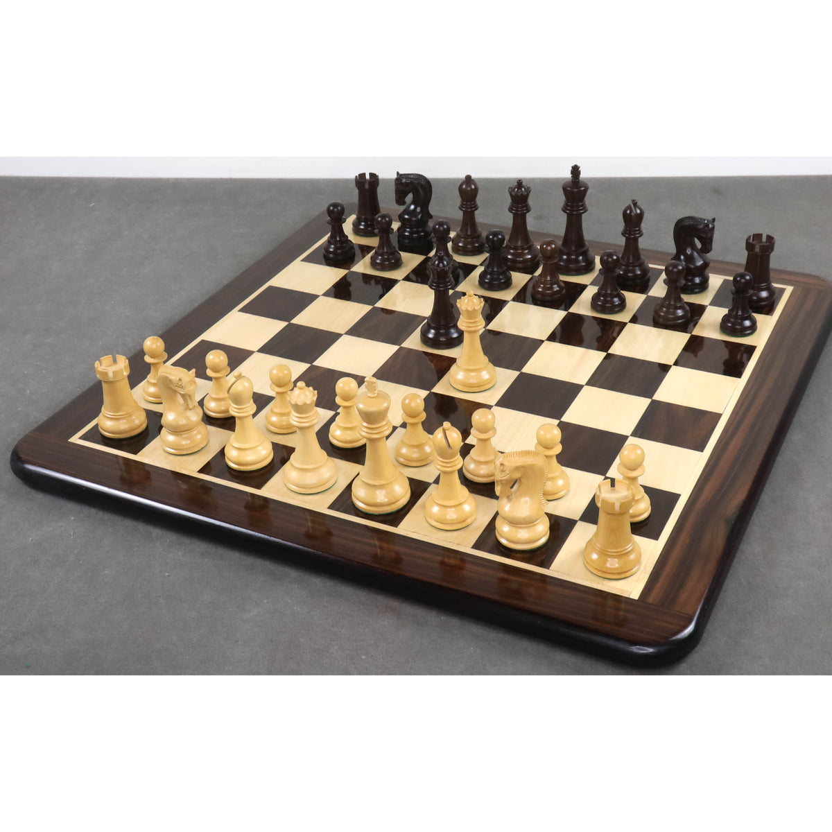 Premium 4 inch Leningrad Staunton chess set displayed on a luxury wooden board.