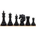 Six dark ebony wood Spartacus luxury Staunton chess pieces lined up to highlight uniform polishing and grain.