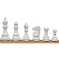 Full set of white lacquered boxwood Prime Staunton chess pieces arranged from king to pawn on a wooden surface.