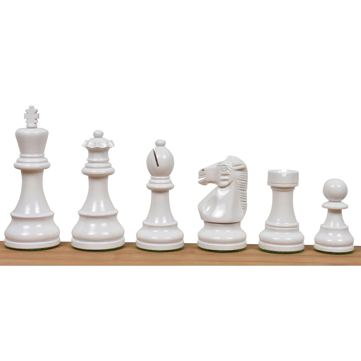 Full set of white lacquered boxwood Prime Staunton chess pieces arranged from king to pawn on a wooden surface.