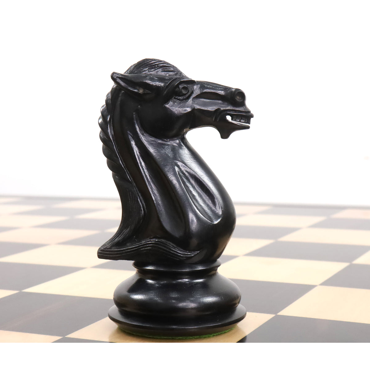 Profile view of a hand-carved ebony knight piece from the luxury Staunton chess set.