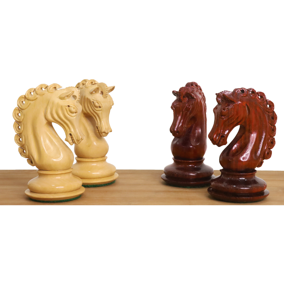 A collection of four knight chess pieces in contrasting bud rosewood and boxwood.