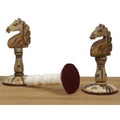 Two carved antique camel bone knights from the English Series Pre-Staunton set, revealing a protective red felt base.