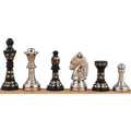 A profile lineup of the six unique silver and black Staunton-style brass chess pieces, displaying their intricate etched designs.