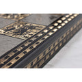 A macro view highlighting the detailed etched patterns and metallic texture along the side rail of the black and silver chess board.