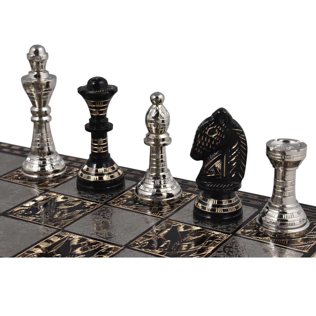 An angled view of the silver King, Queen, Bishop, Knight, and Rook lined up on the intricate silver and black chessboard.