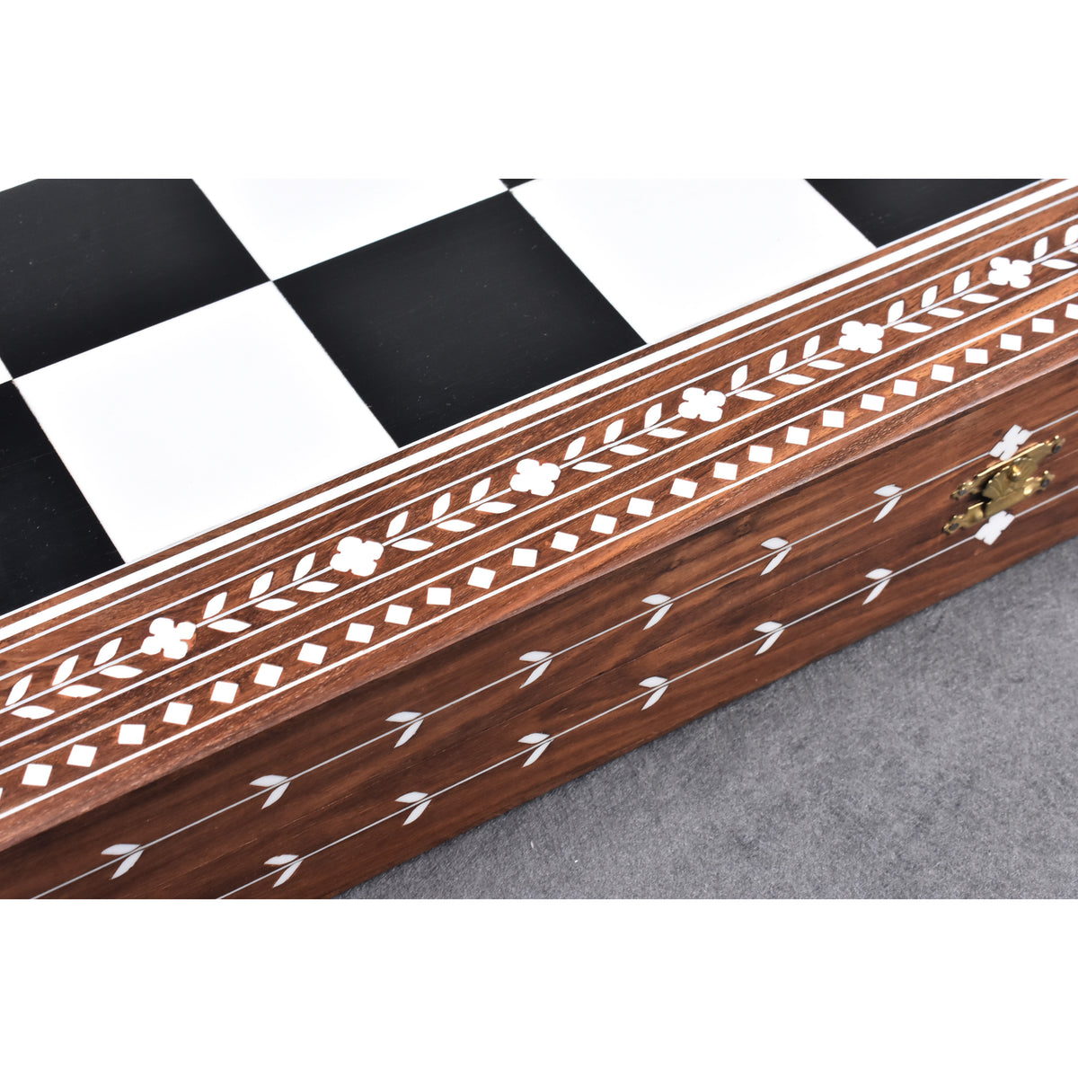Close-up of the handcrafted floral white inlay work on the border of a premium Golden Rosewood chess board.