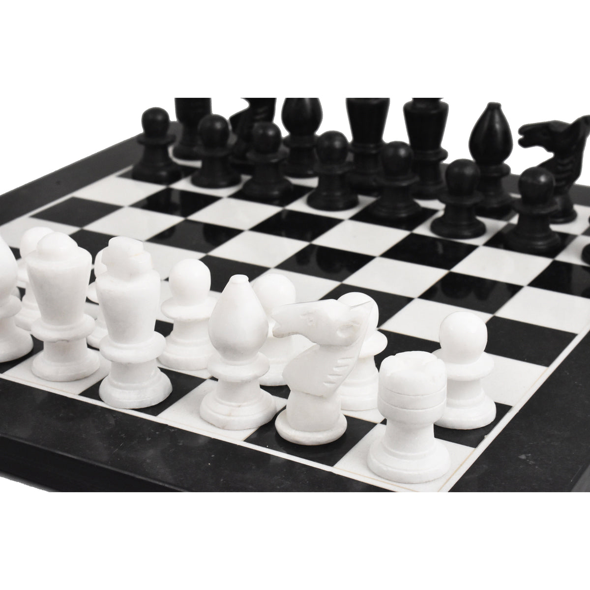 Close-up of white marble chess pieces on a black and white stone board.