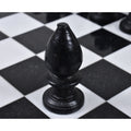 Macro shot of a single black marble chess bishop on the board.