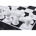 Detailed view of a hand-carved white marble chess knight on the board.