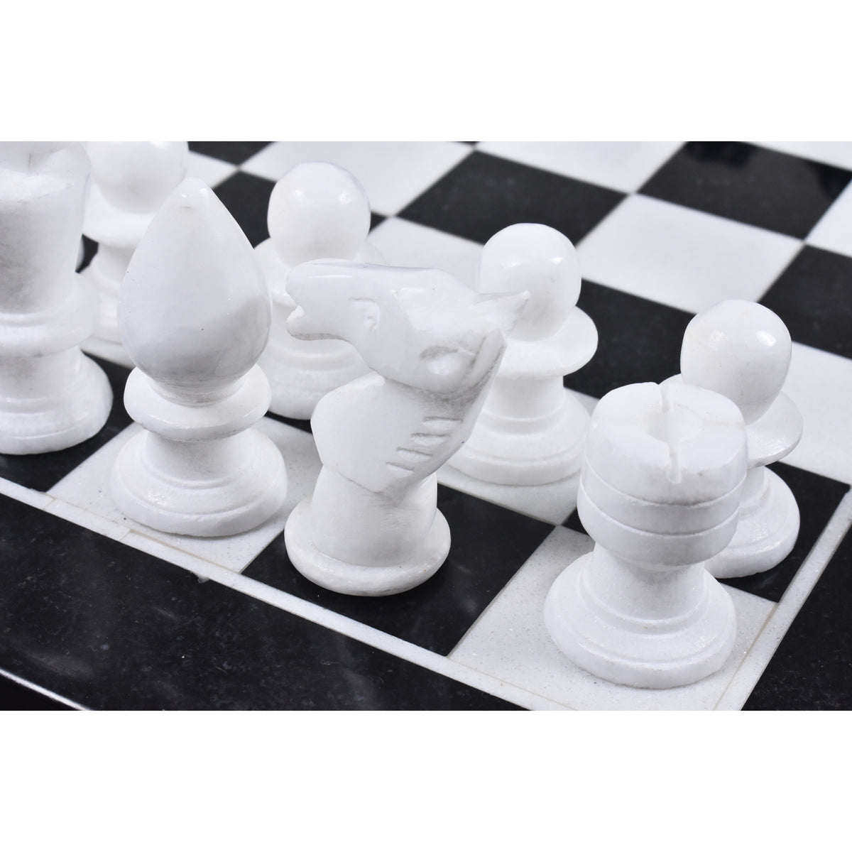 Detailed view of a hand-carved white marble chess knight on the board.