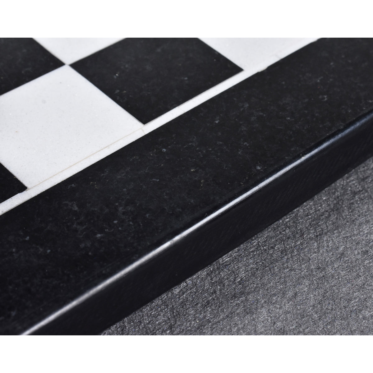 Macro detail of the polished black and white marble chessboard border.
