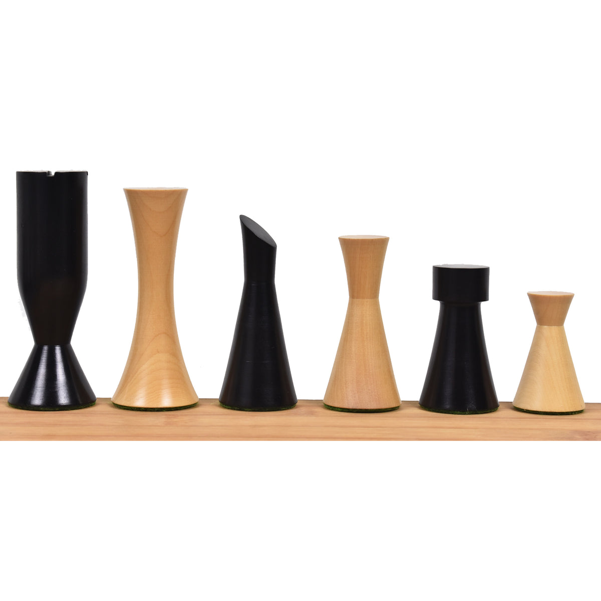 Mixed ebonized and boxwood 3.4" Minimalist Tower chess pieces arranged by height on a wooden ledge.