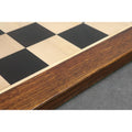 Side profile view showing the thick golden rosewood border and smooth finish of the professional ebony and maple chessboard.