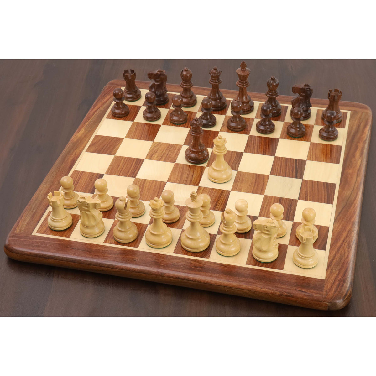 Complete golden rosewood and boxwood pieces from the Reykjavik Series Staunton chess set set up on a wooden board.