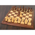 French Grandmaster chess set arranged on a wooden chessboard ready for play.