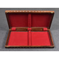 Interior of the folding wooden chess board featuring red felt lining and storage compartments for chess pieces.