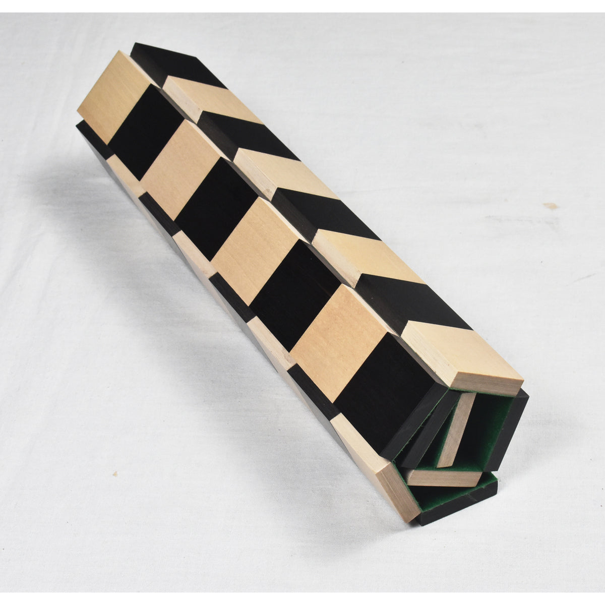 Side profile of the compact roll up travel chess board showing interlocking wooden design.