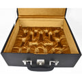 Open black leatherette chess coffer showing empty gold velvet lined slots.