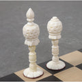 Light side King and Queen from the 3.7" English Series Pre-Staunton camel bone chess pieces resting on a chessboard.
