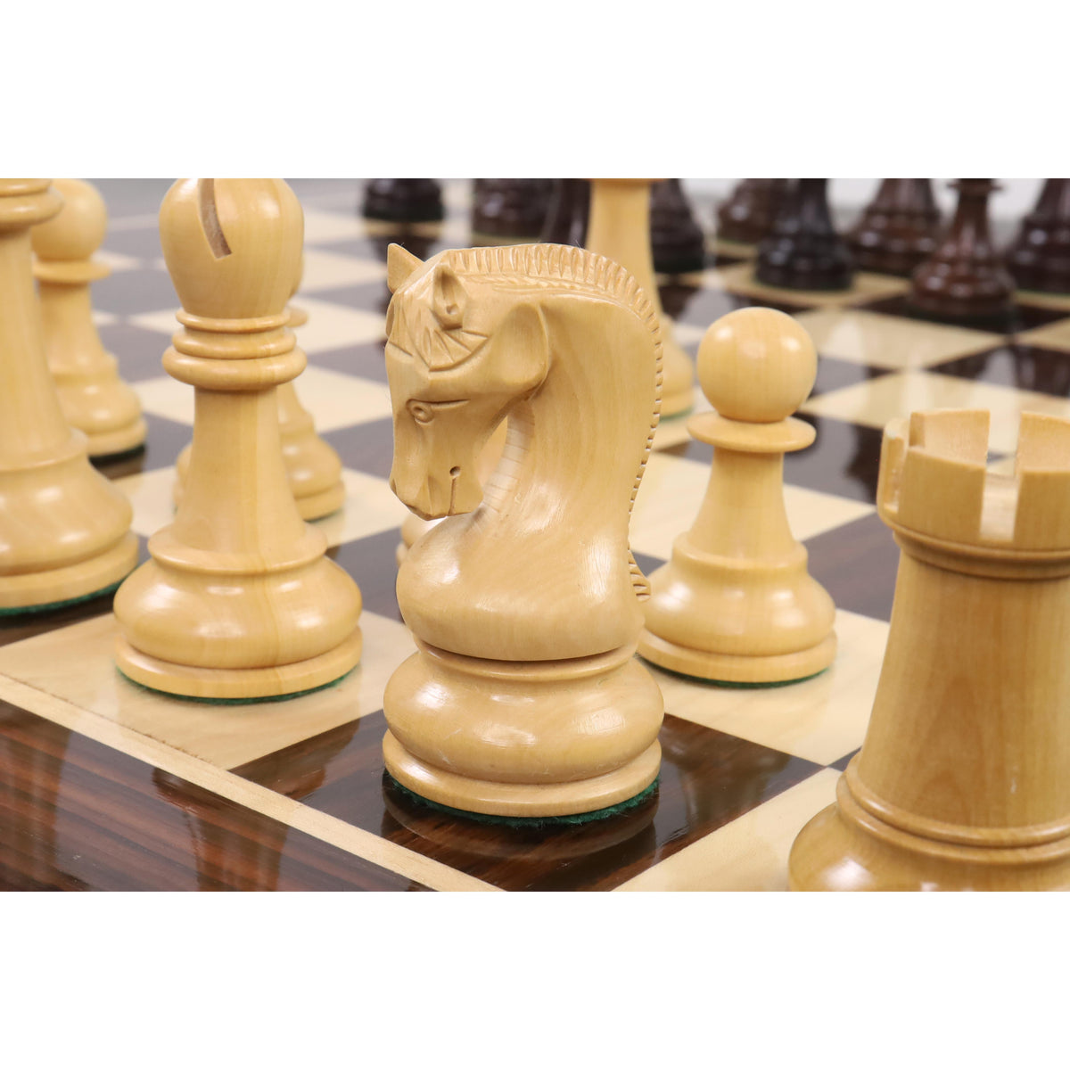 Close-up shot of a boxwood Leningrad Staunton knight on a wooden chessboard.
