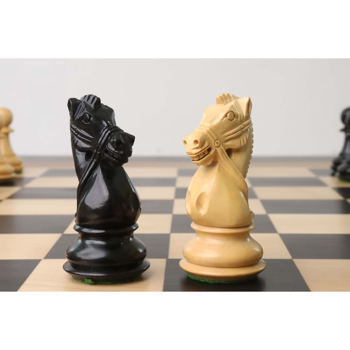 Close-up of black and natural weighted knights from the Supreme Luxury Staunton set.