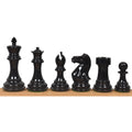 Set of black painted Staunton chess pieces arranged in a row.