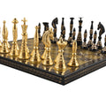 Detailed macro perspective of handcrafted solid brass Warli tribal chess pieces on an engraved metal board.
