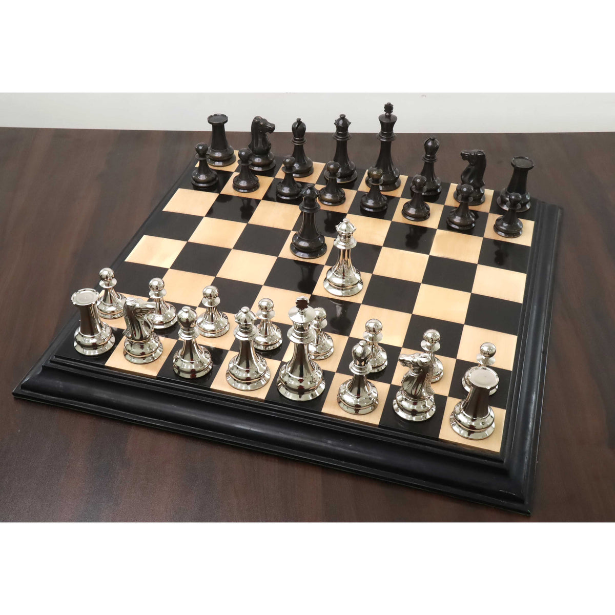 1849 Jacques Staunton luxury brass chess pieces arranged fully on a sleek black and wood chess board.